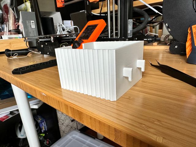 Rear view of the sticky note holder assembled and with two pegs sticking out from the back.