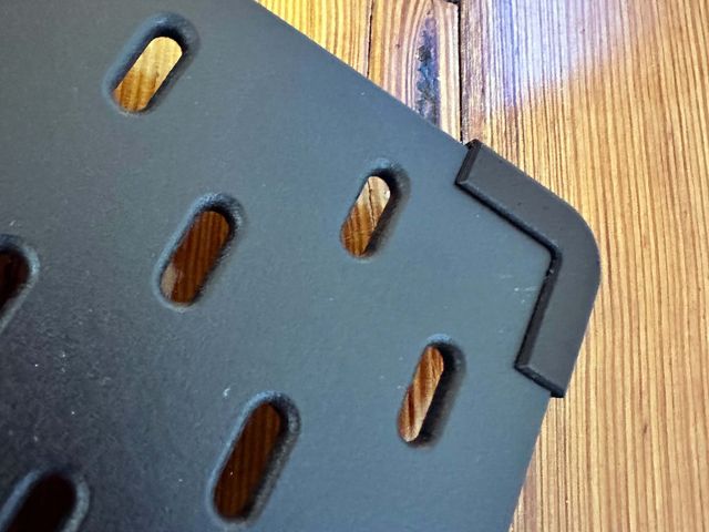 The corner of a pegboard, now with a corner bumper slotted over the corner.