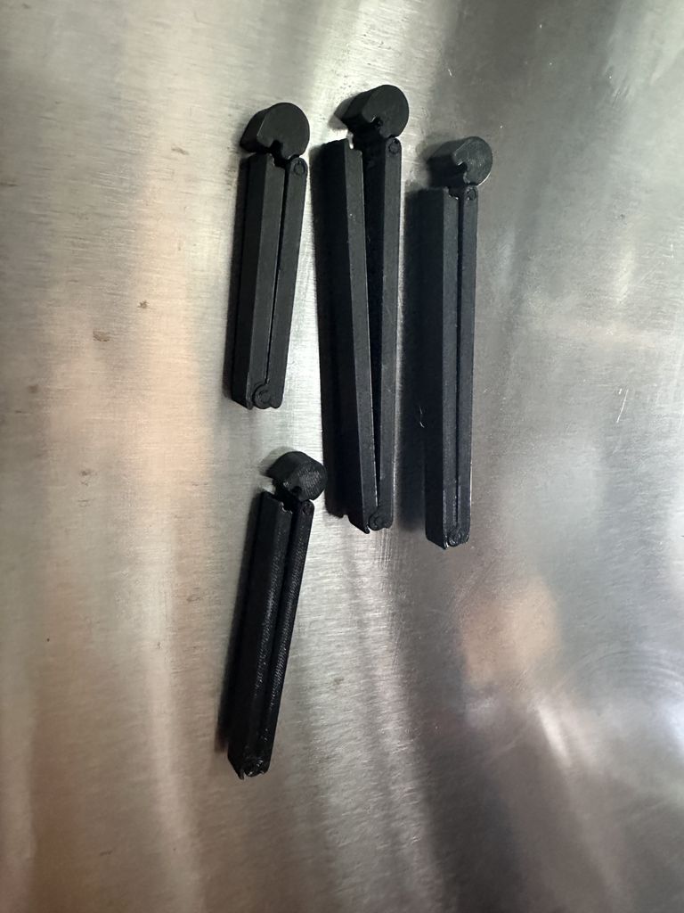 A batch of clips of varying sizes stuck to a refrigerator door