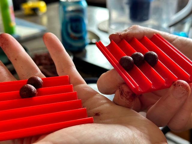 The red plastic pieces now opened up with round clay beads in the channels.