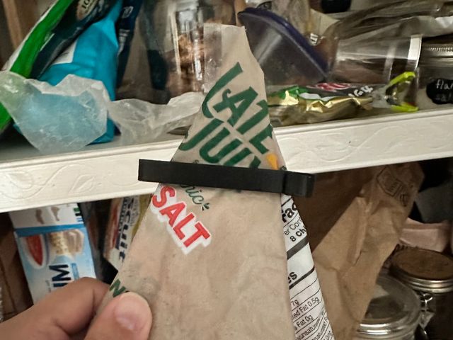 A batch of clips of varying sizes stuck to a refrigerator door